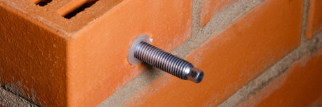 Threaded metal rod inserted through a hole in the wall