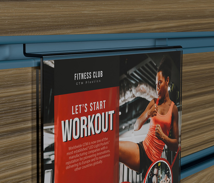 A zoomed in photo of an acrylic slatwall portrait poster holder that shows men and women performing physical exercises. The shape of the slatwall section is clearly visible.