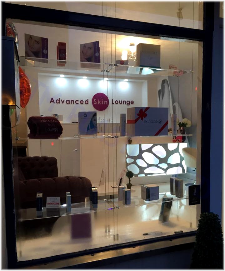 Acrylic wire suspended shelving mounted against the wall in a cosmetics retail store