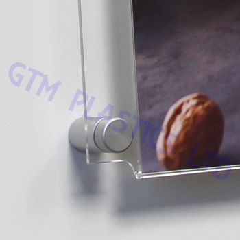 A closeup view of an easy access poster holder's bottom-left satin finish stand-off clamp, whilst it's attached to the wall.